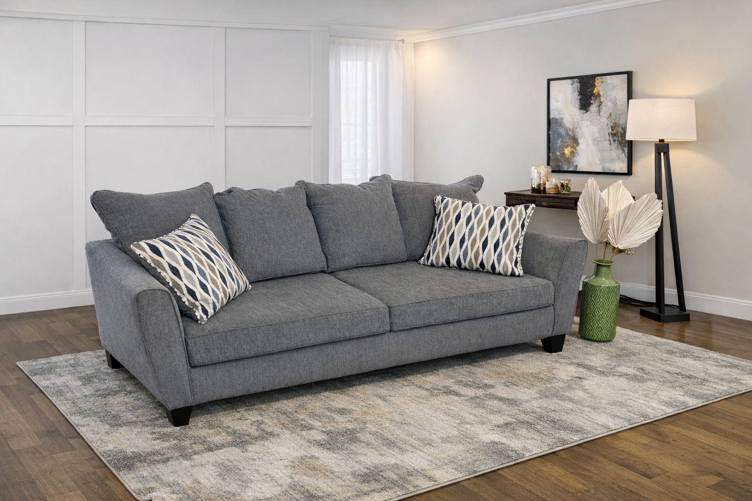 Modern gray fabric sofa with two patterned accent pillows
